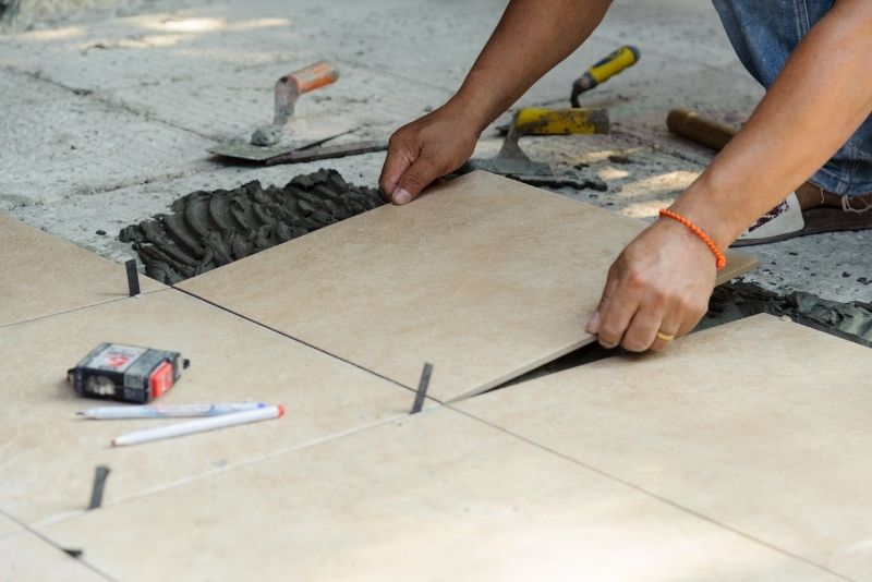 Tiler laying ceramic floor tiles for a residential client